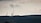 Telecommunication towers are silhouetted against a cloudy sky, standing on a hilly terrain covered with dark vegetation. The scene is calm yet somewhat imposing, with an overcast atmosphere.