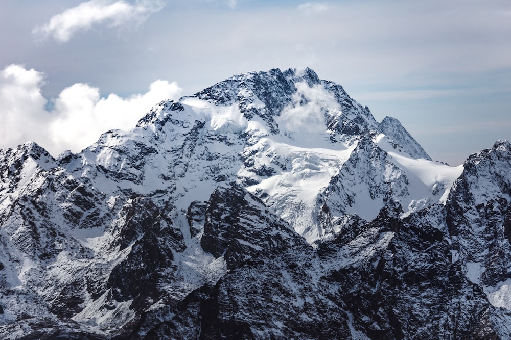 snow covered mountain under cloudy sky during daytime