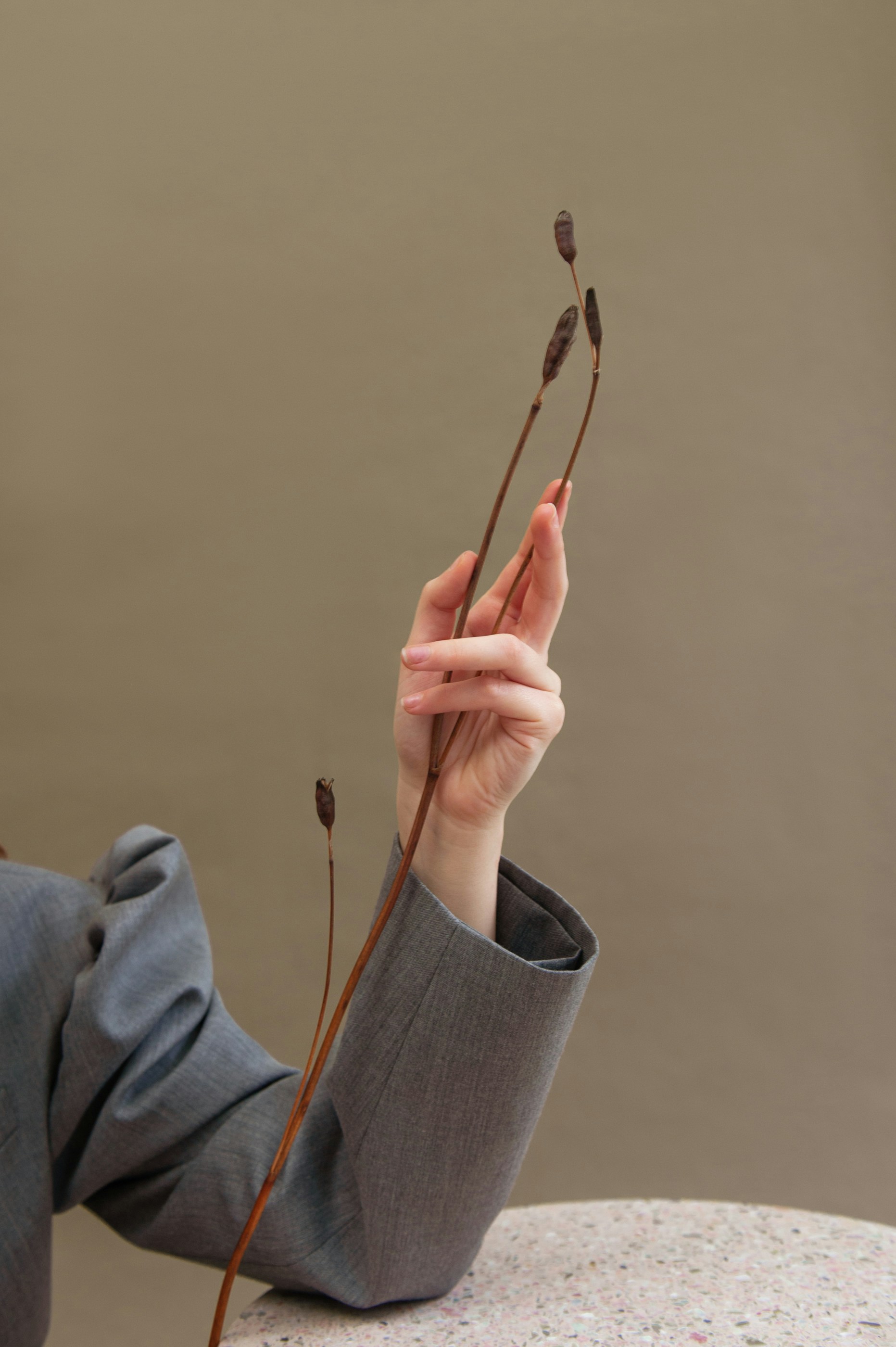 person in gray sweater holding silver necklace
