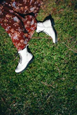 A street style shot of a model wearing a mint green oversized sweater and chunky white boots.