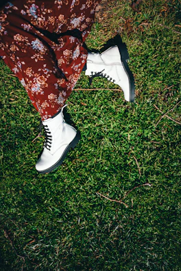A street style shot of a model wearing a mint green oversized sweater and chunky white boots.