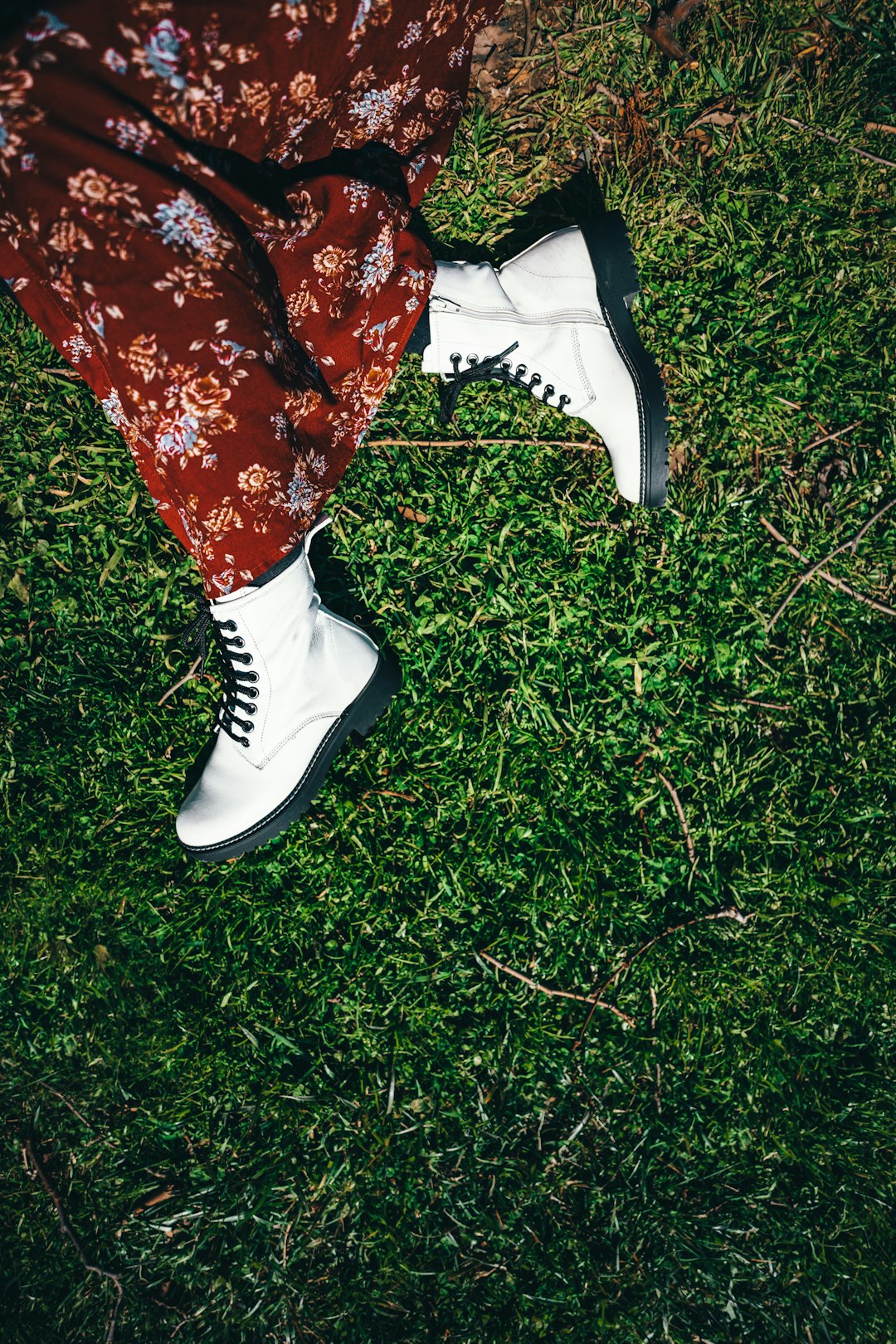 person in red and black floral pants and black and white nike sneakers