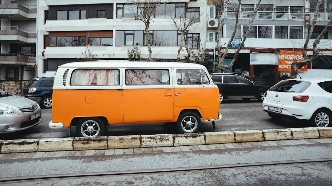 orange and blue volkswagen t-2 parked on sidewalk during daytime