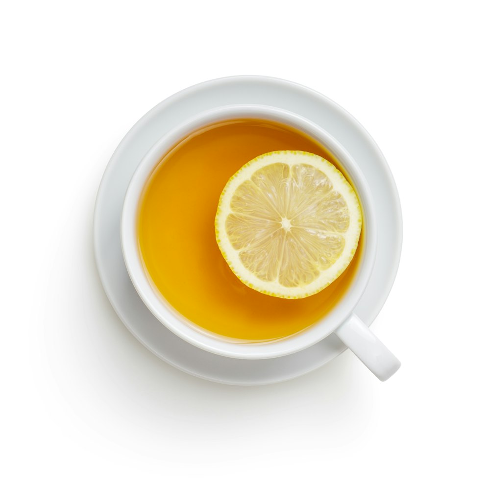 taza de cerámica blanca con jugo de limón