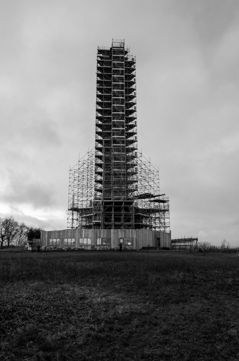 grayscale photo of building under cloudy sky