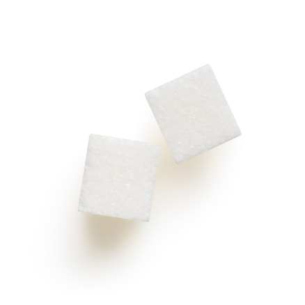 Two white sugar cubes positioned diagonally on a plain white background.