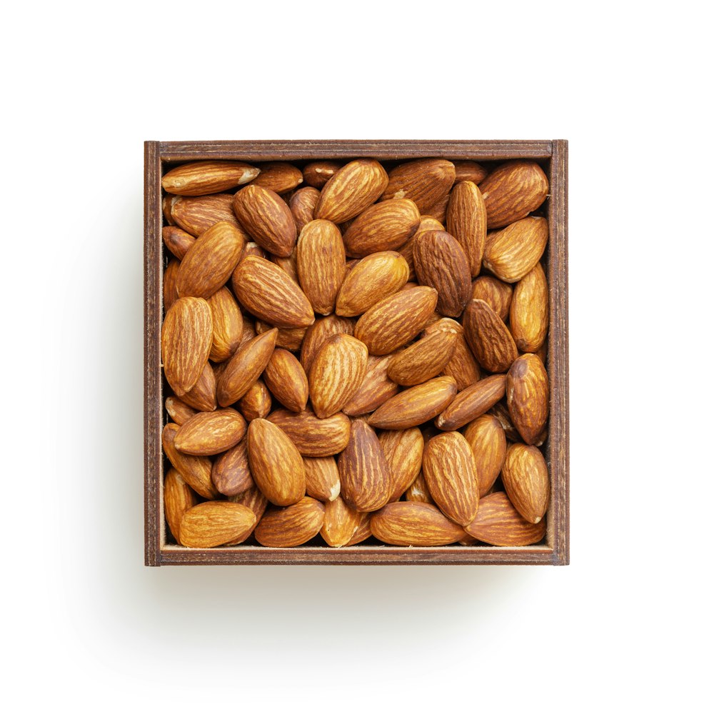 brown almond nuts on white surface