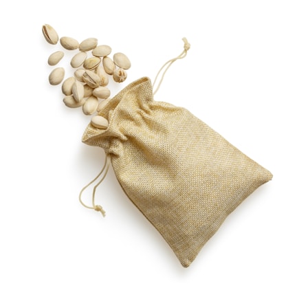 Close-up of vibrant green pistachios spilling from a rustic burlap sack
