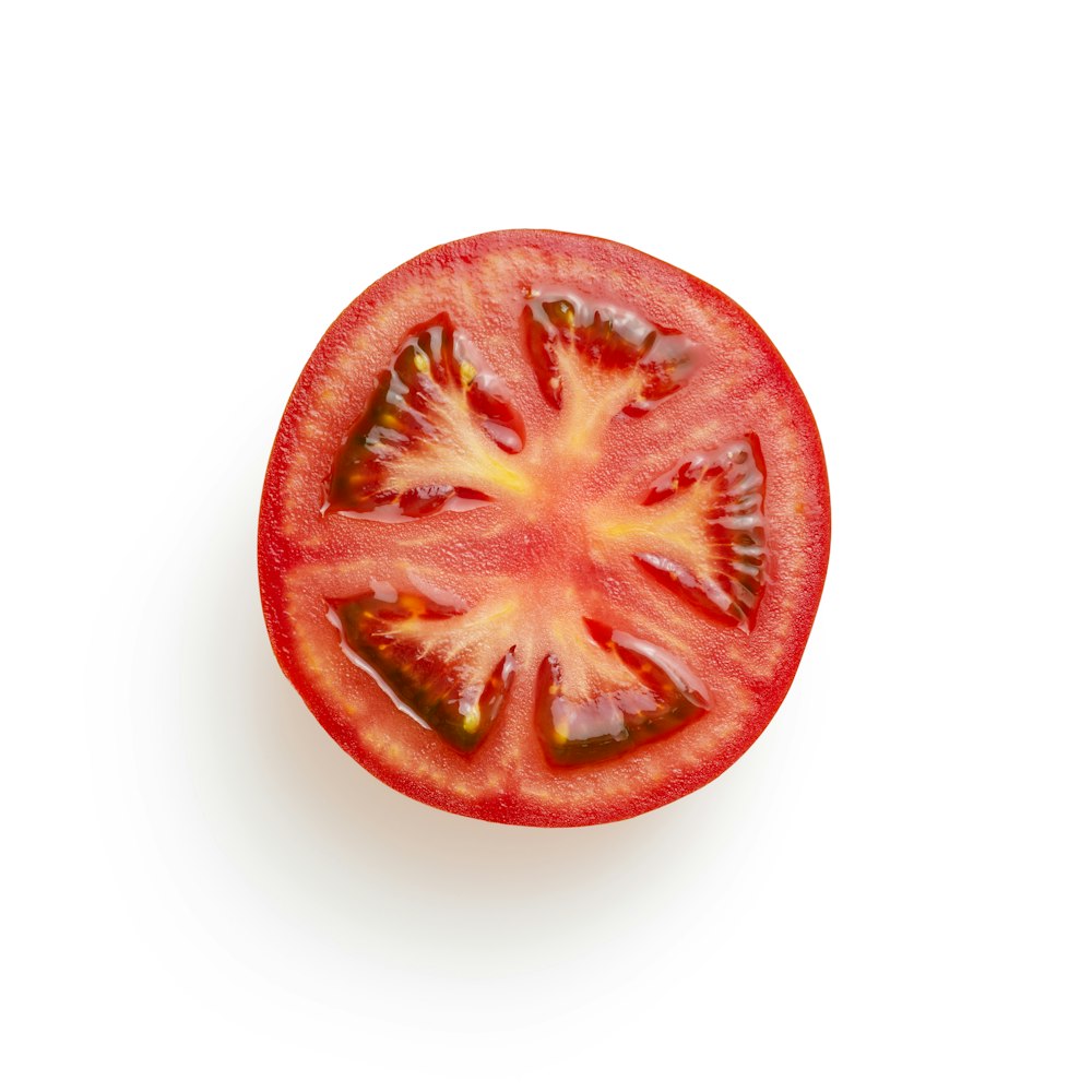 in Scheiben geschnittene Tomate auf weißer Oberfläche