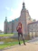A smiling young student standing in front of a historic Irish castle on a sunny day.