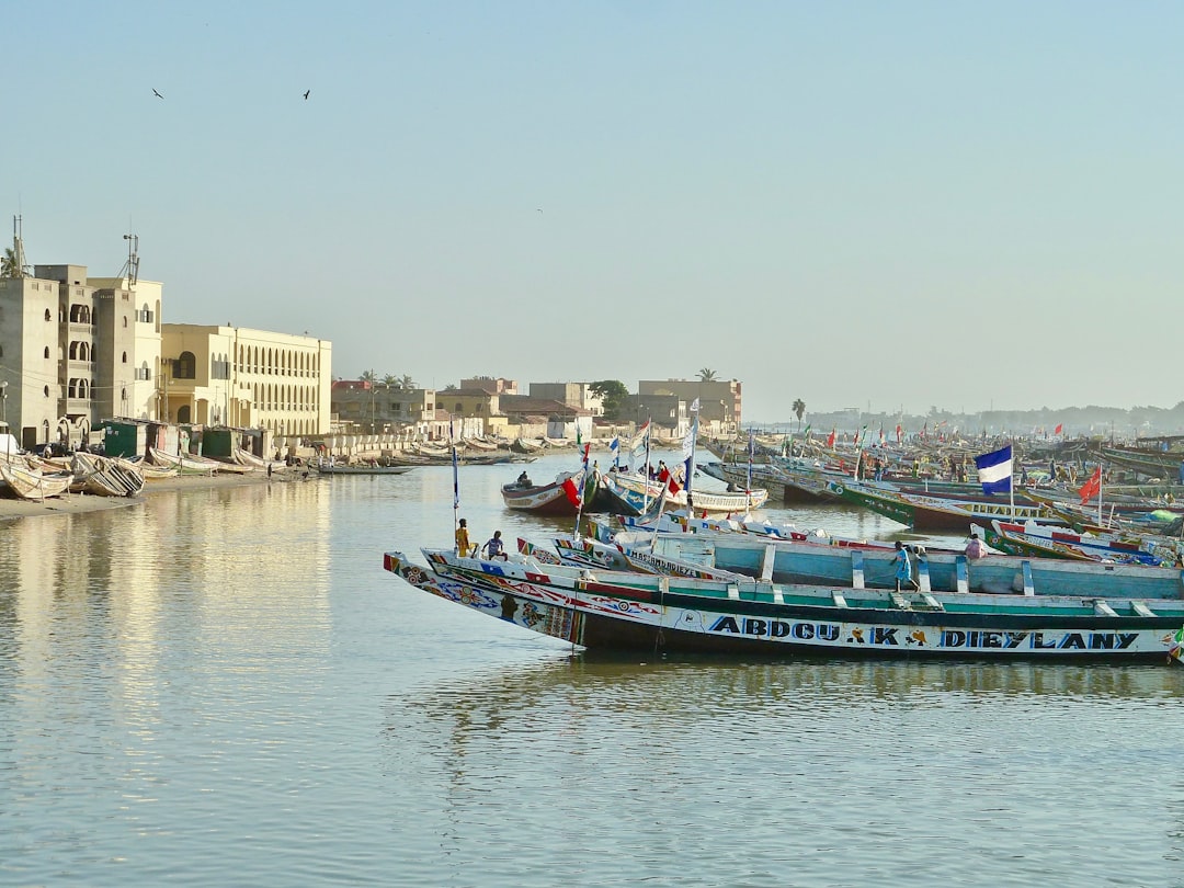 blue and white boat on water near city buildings during daytime