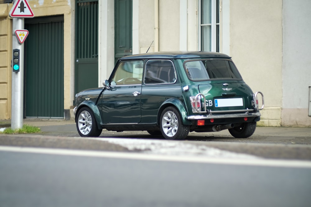 green station wagon parked beside white building