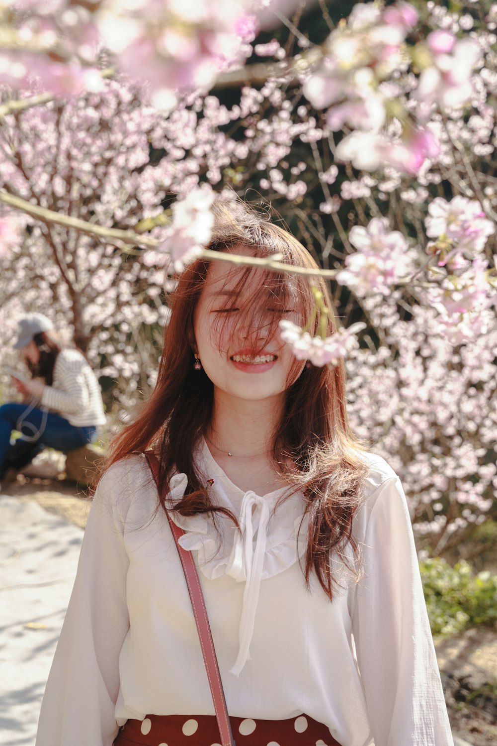 woman in white shirt with pink flower on her hair