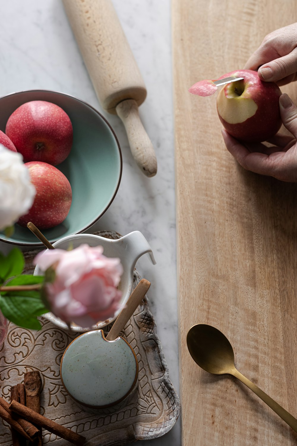 person holding white ceramic bowl with sliced apples