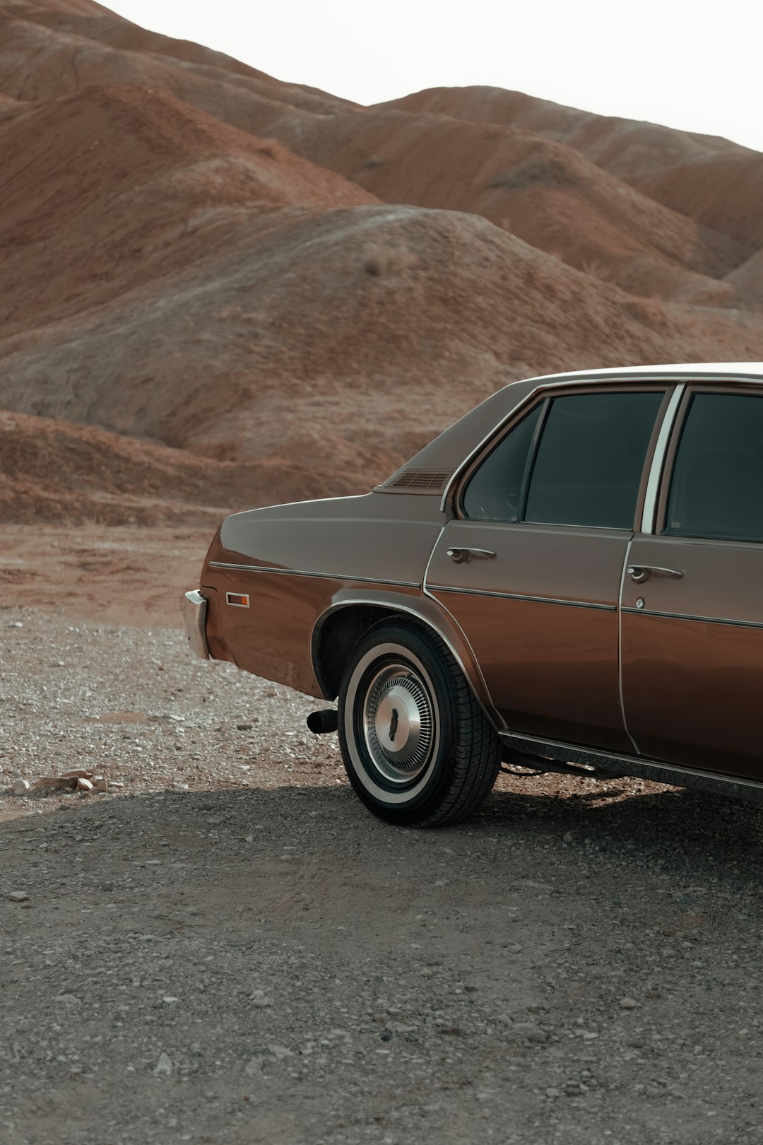 brown and white vintage car on brown dirt ground during daytime