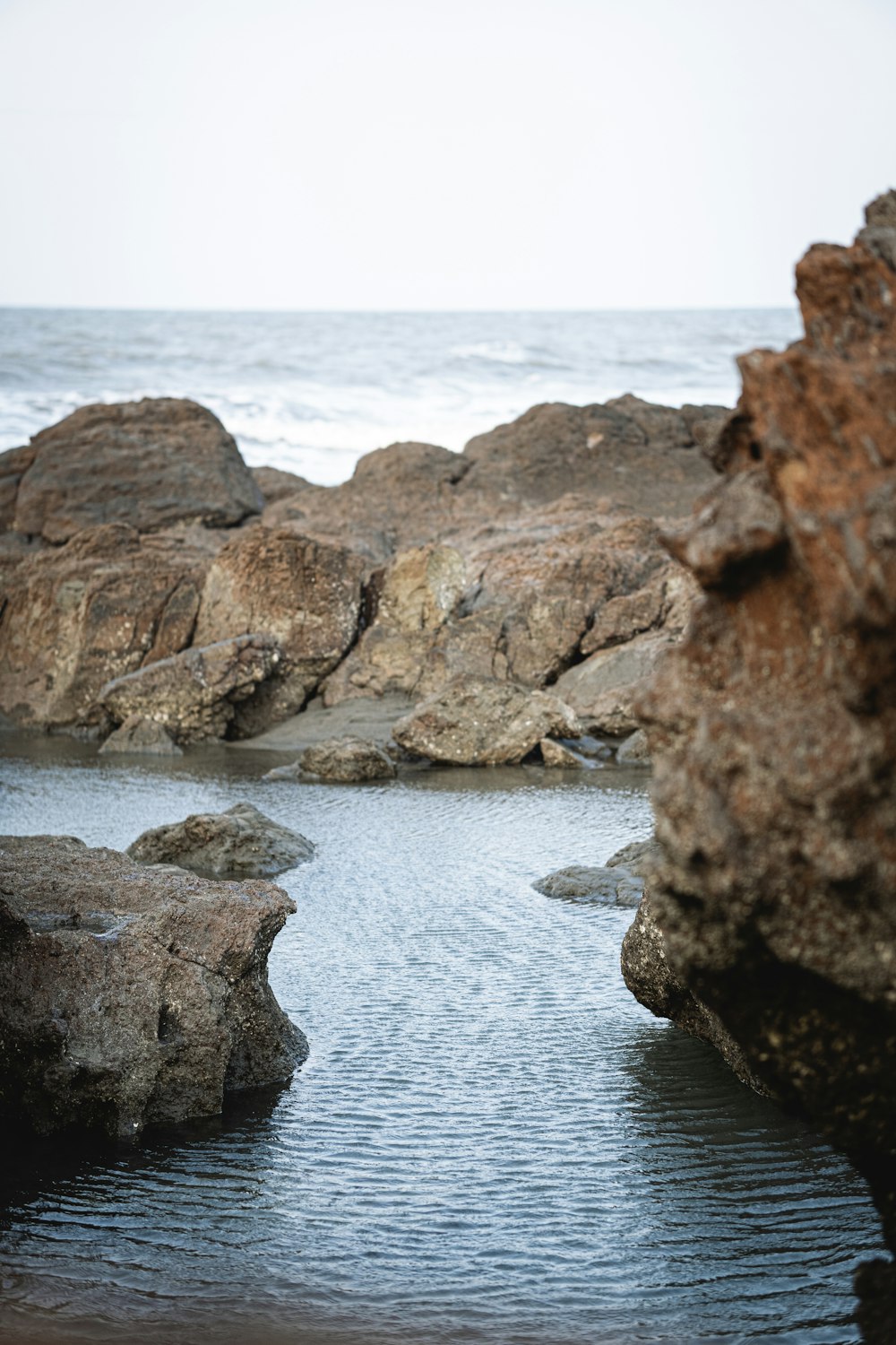 brown rock formation near body of water during daytime