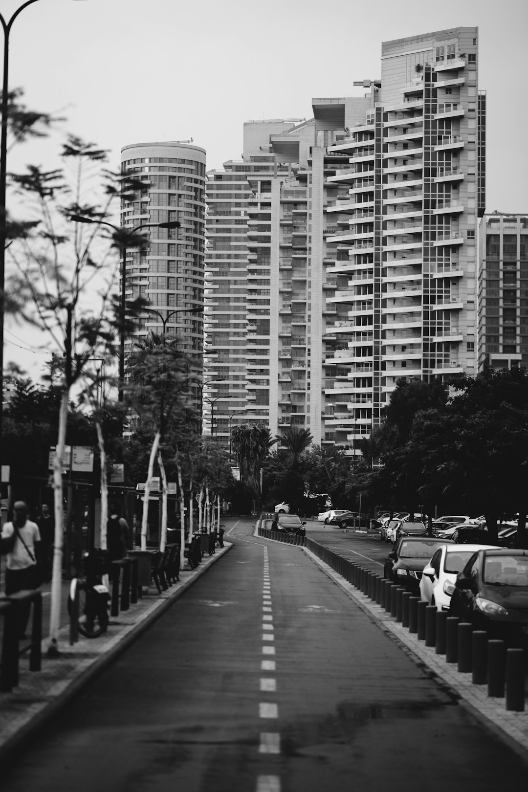 grayscale photo of cars on road near high rise buildings