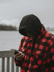 A person checking weather updates on a smartphone outdoors.