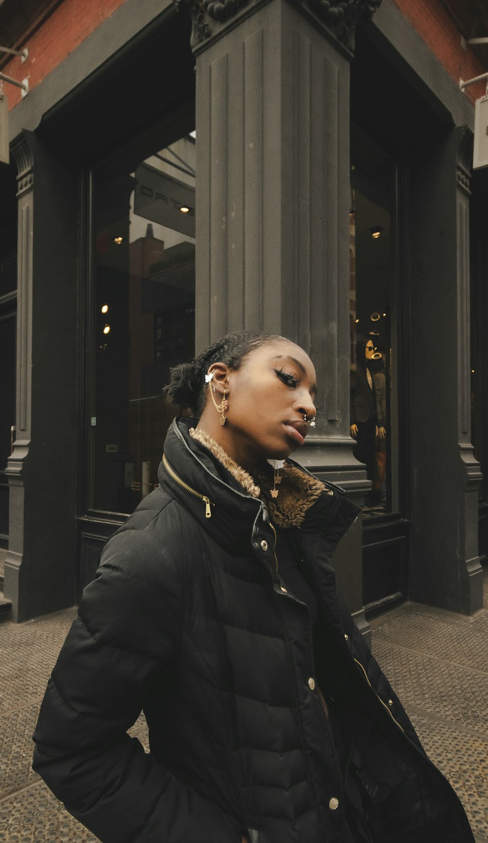 woman in black leather jacket standing near black wooden door