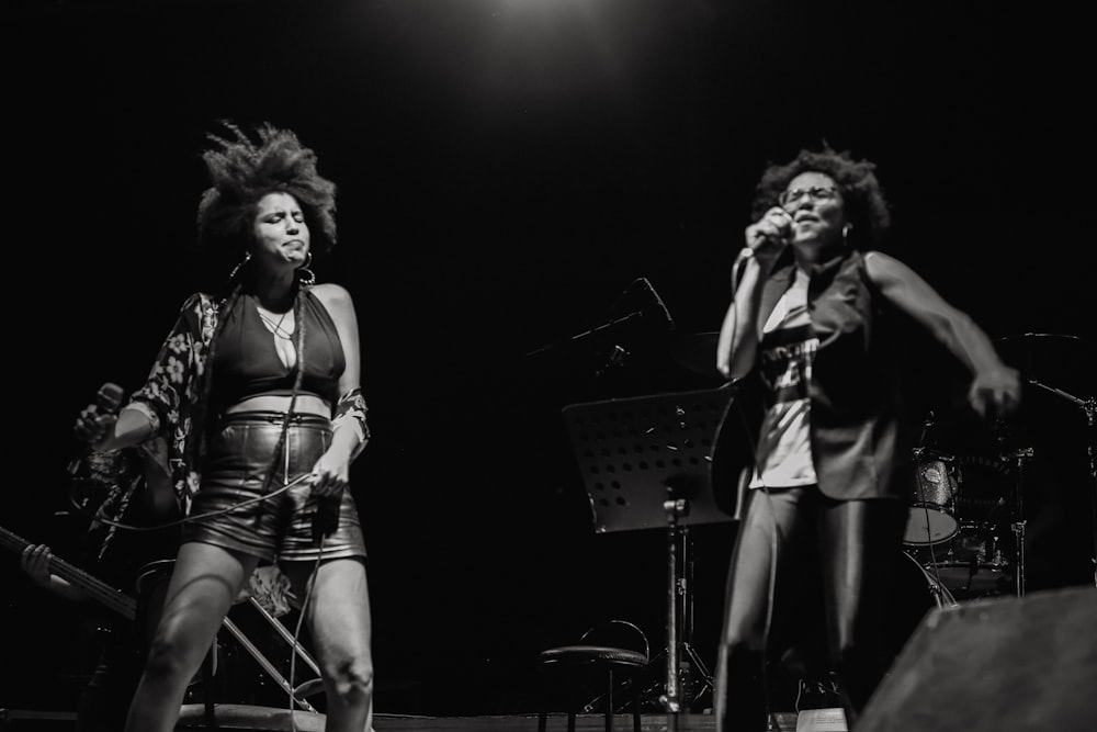 woman in black and white stripe tank top singing on stage