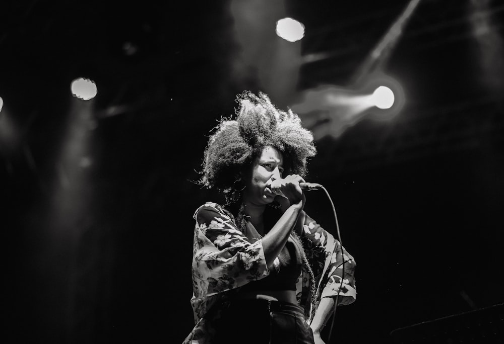 woman in black and white floral dress singing