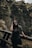 woman in black t-shirt and black sunglasses sitting on brown wooden fence during daytime