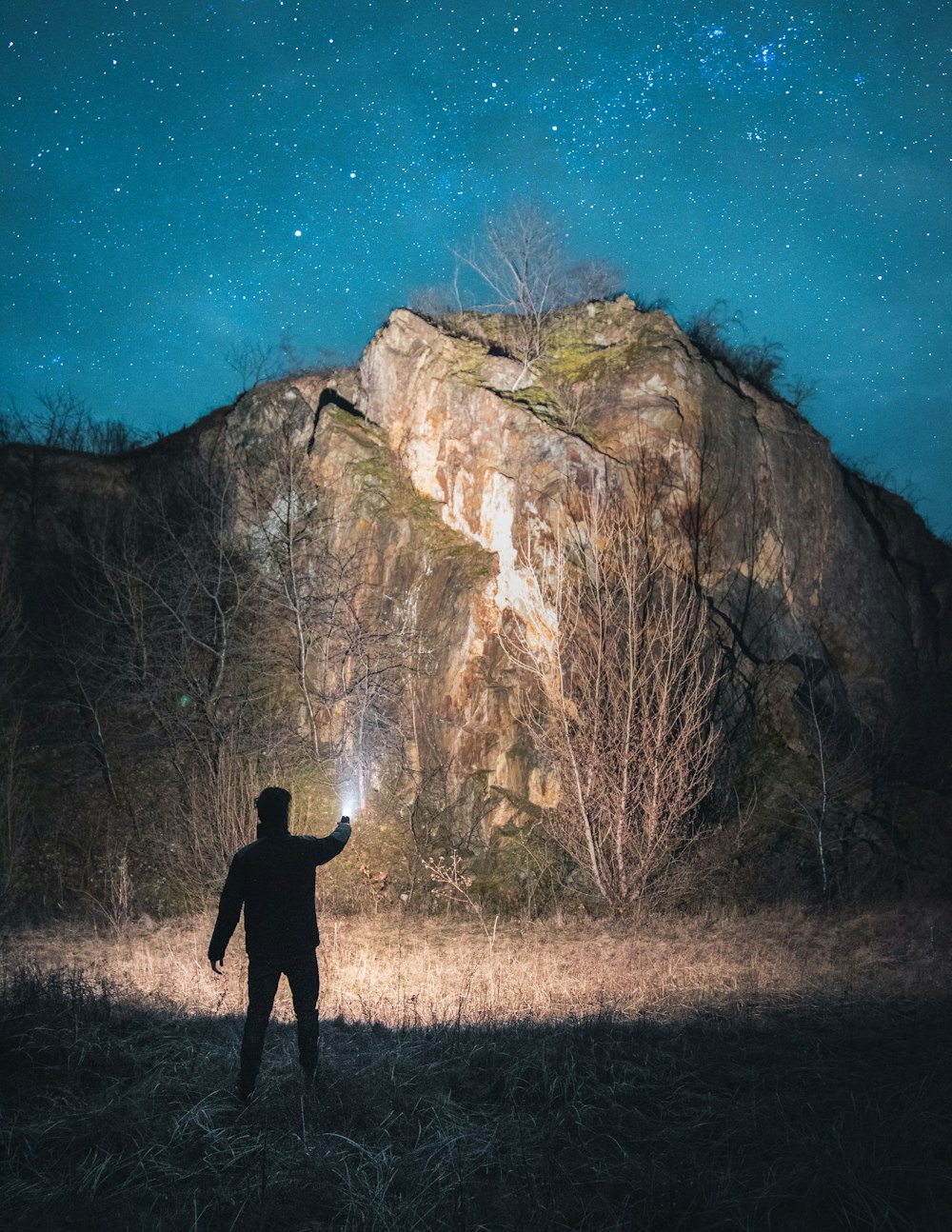 person in black jacket standing near brown rock formation during daytime