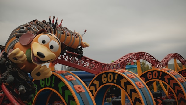 mickey mouse riding on red and blue roller coaster
