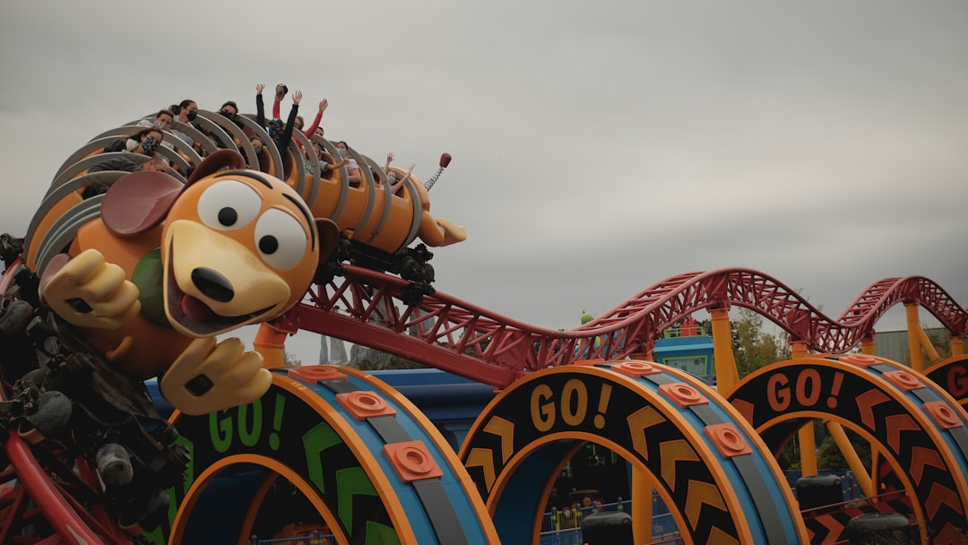 mickey mouse riding on red and blue roller coaster,
