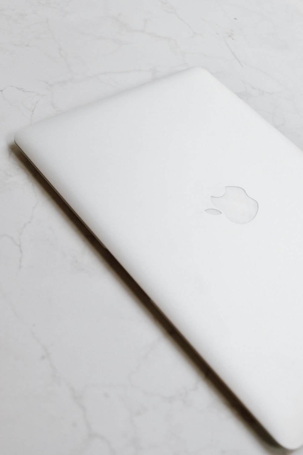 white macbook on white textile