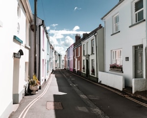 A warm sunlit street in a charming Cádiz village with colorful houses and cobblestone pavement.