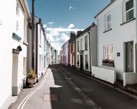 A warm sunlit street in a charming Cádiz village with colorful houses and cobblestone pavement.