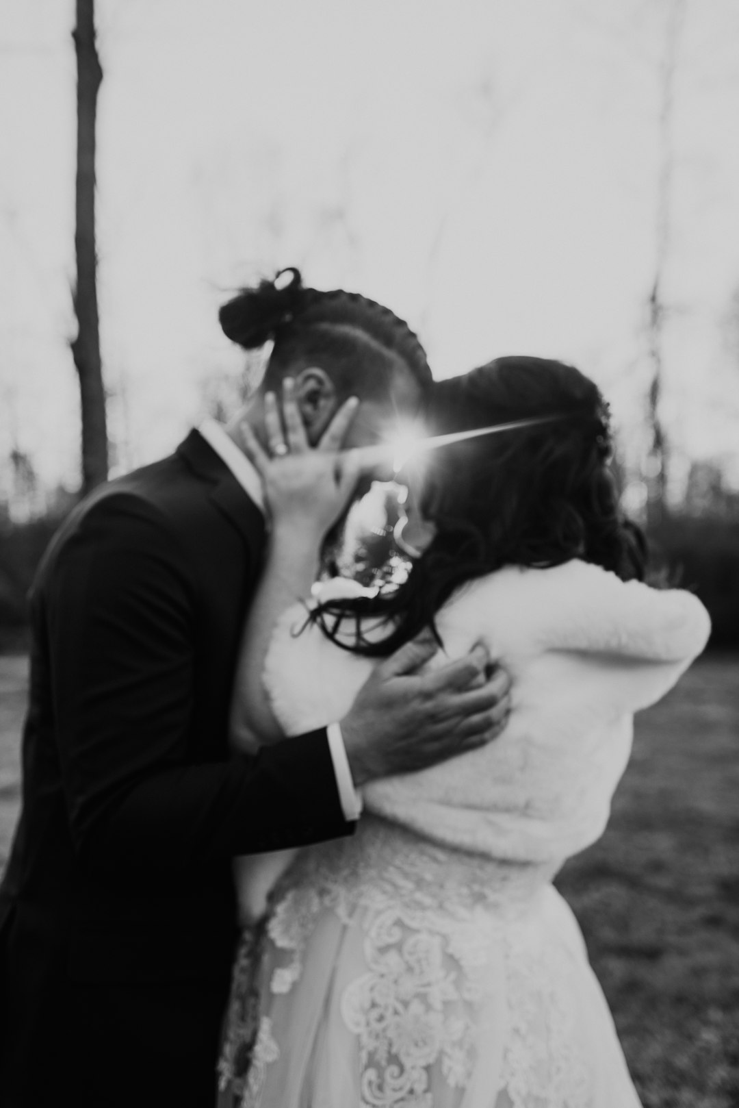 man in black suit kissing woman in white sweater