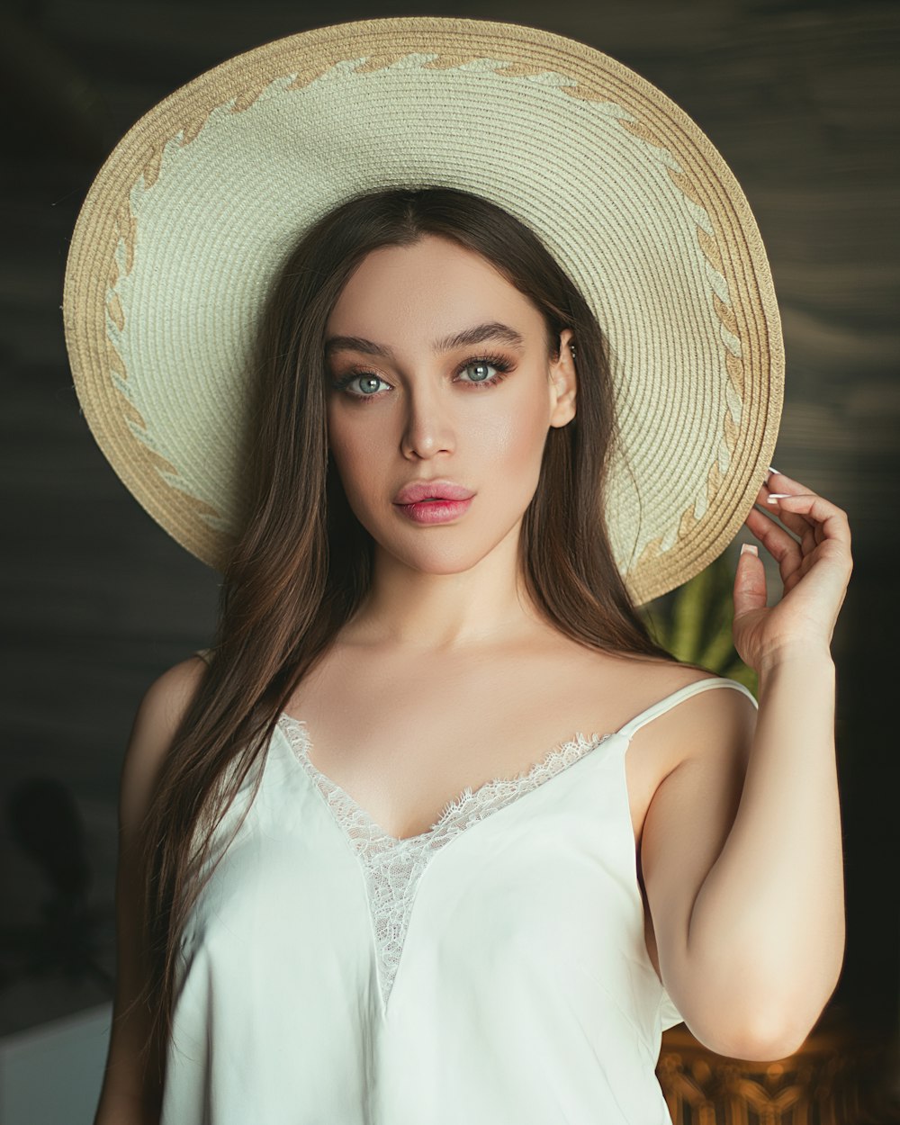 woman in white halter top wearing brown straw hat