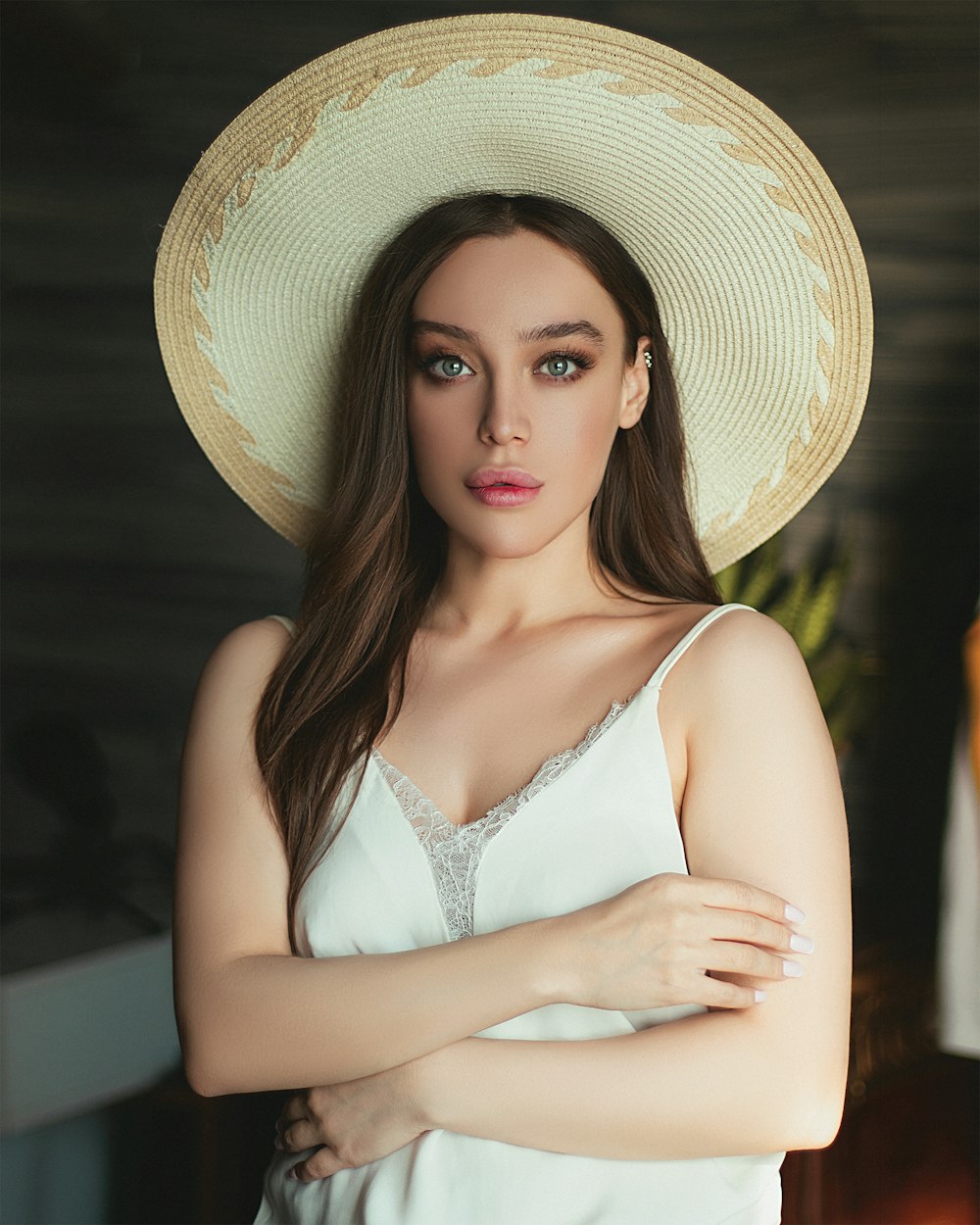 woman in white spaghetti strap top wearing brown straw hat