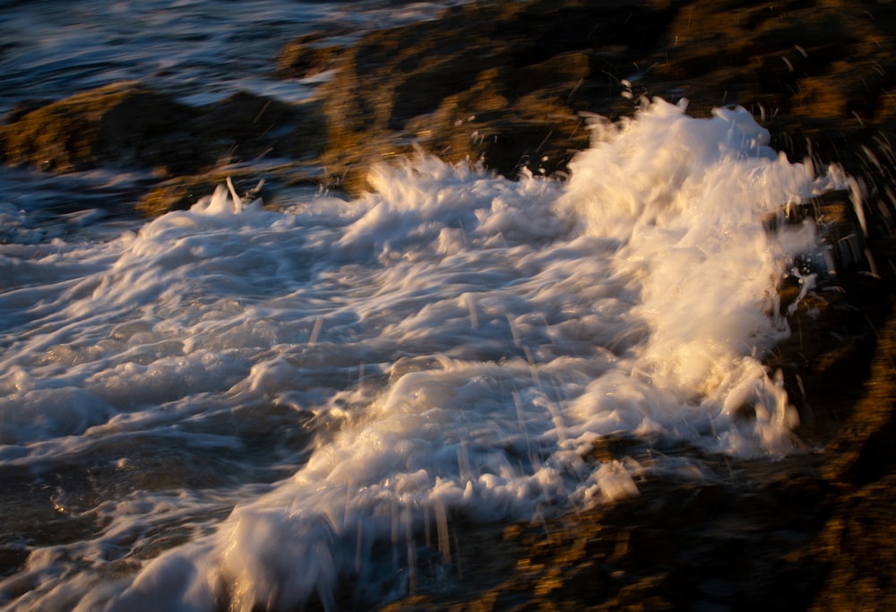 ocean waves crashing on rocks during daytime