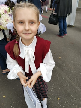 A smiling young girl proudly holding a new school bag donated by the trust.