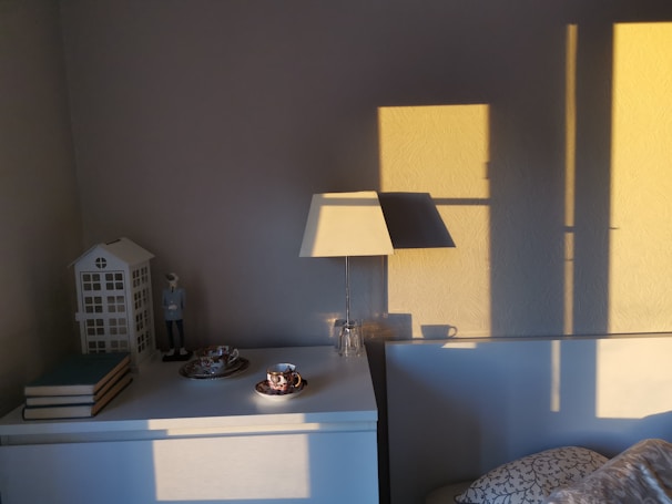 A bright living room corner featuring the foldable side table with a cup of coffee and book on top.