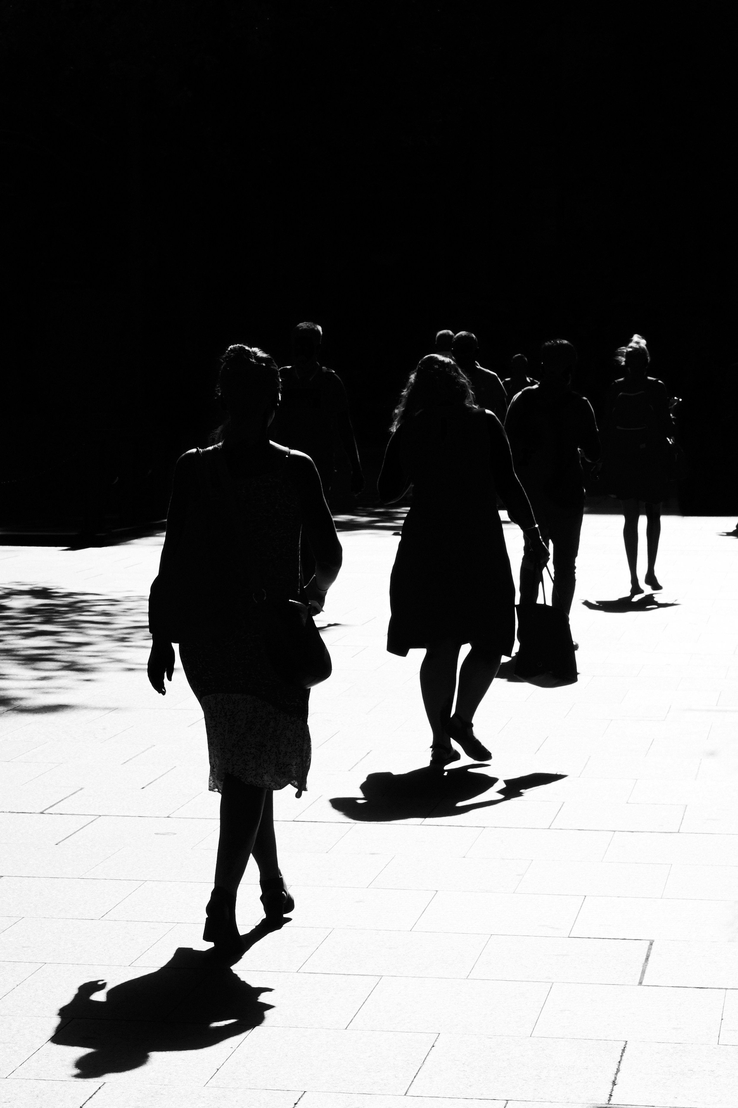 Backlit by low, afternoon light. People walking through Martin Place towards Wynyard station.