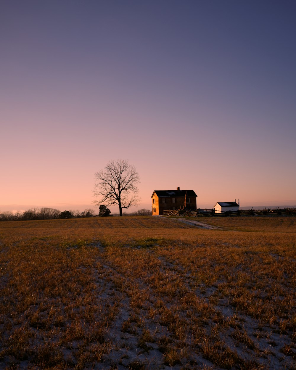 Casa marrón en un campo de hierba marrón durante el día