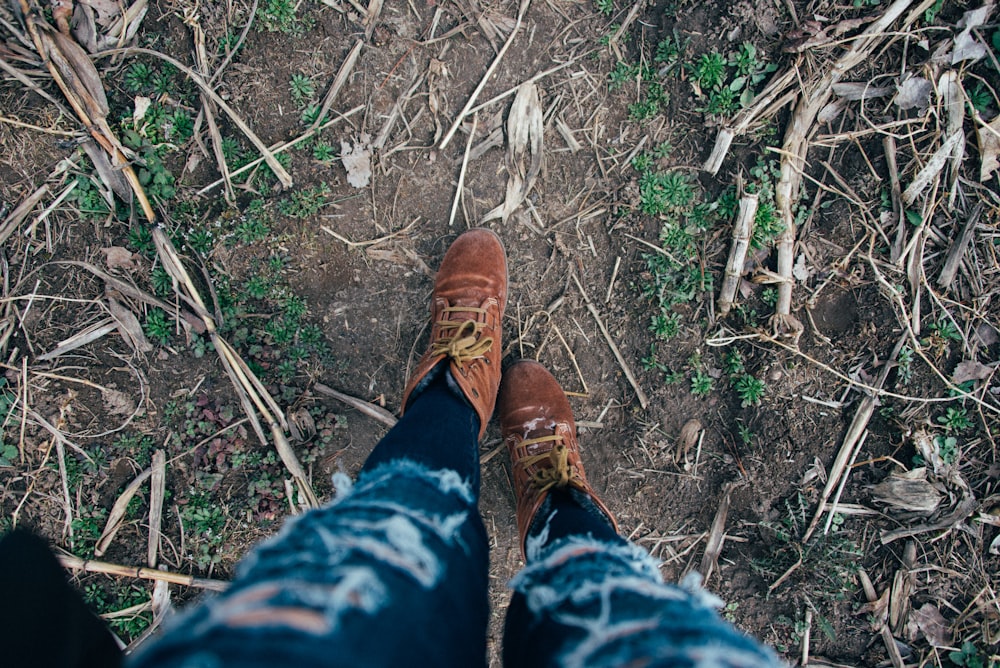 person in blue denim jeans and brown leather shoes