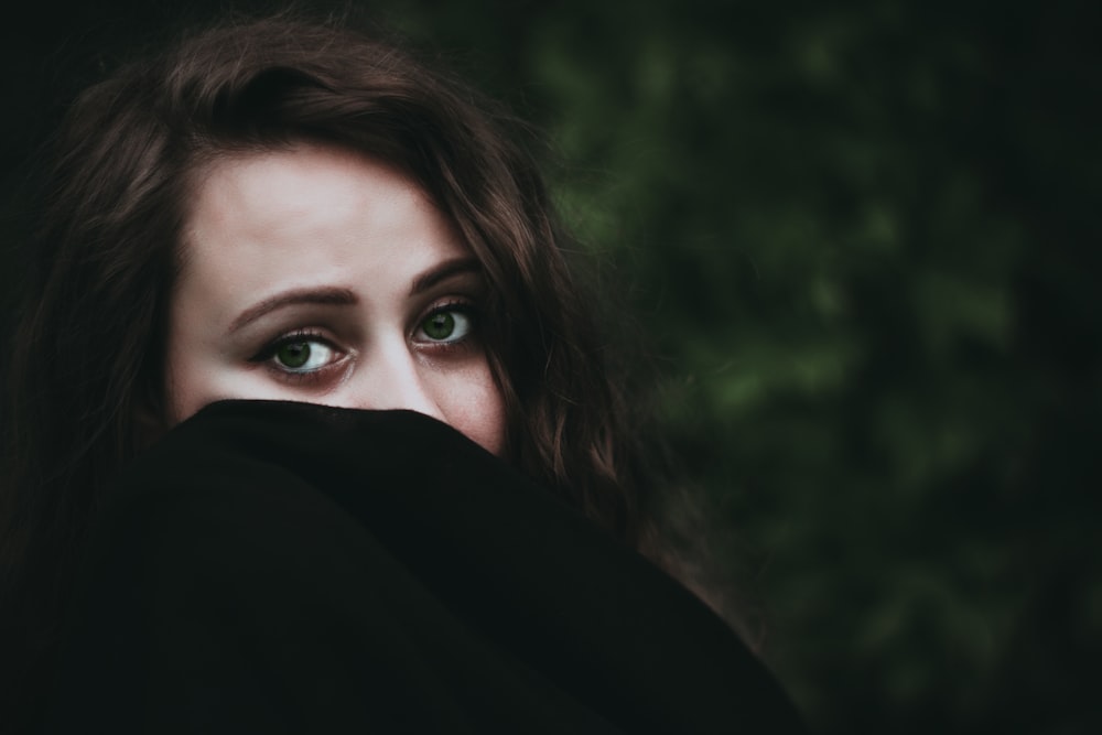 woman covering her face with black textile