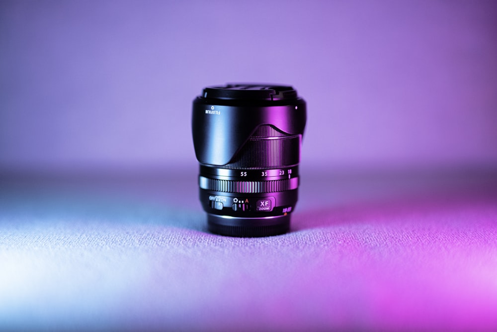 black camera lens on pink and white table