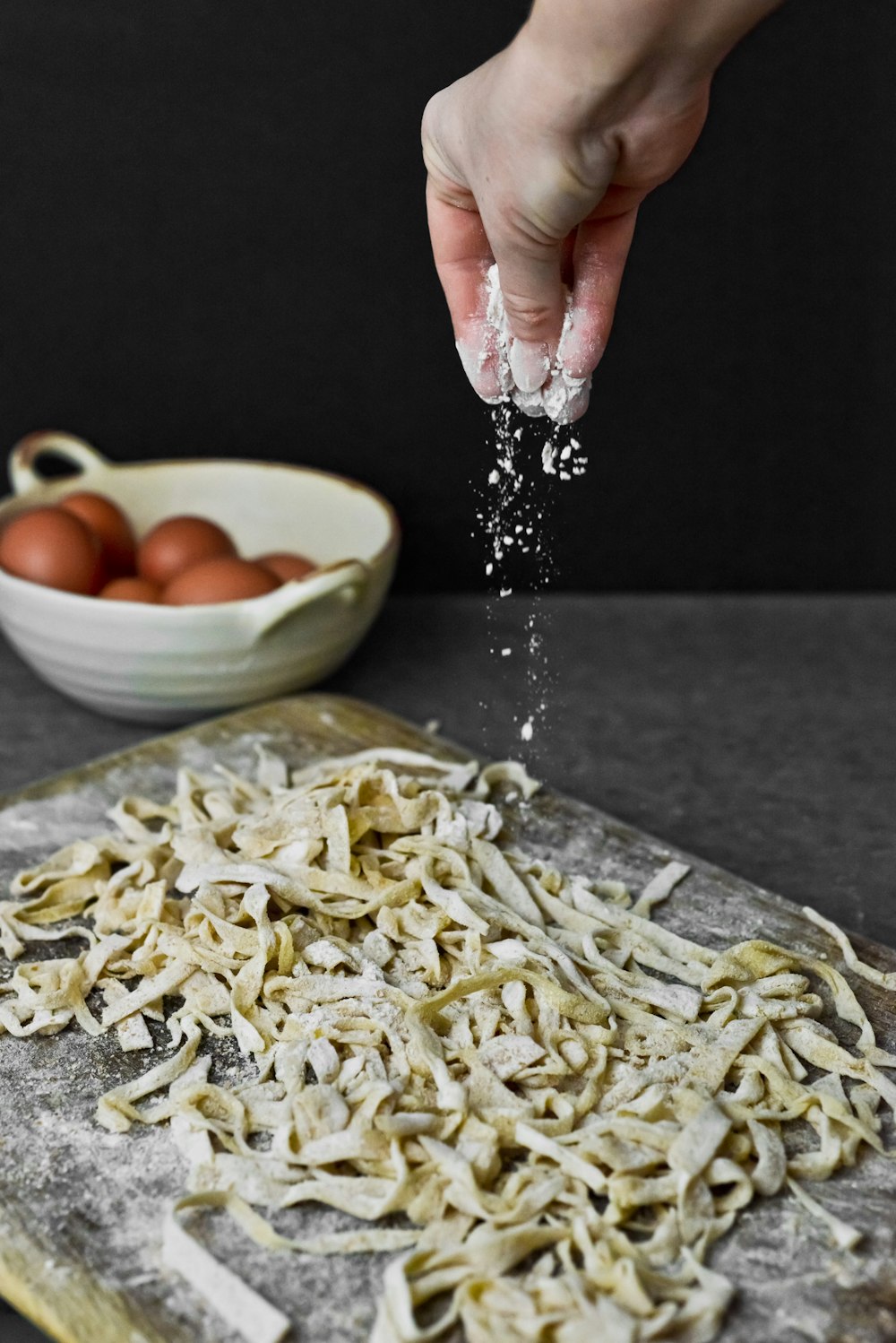 person holding white ceramic bowl with pasta