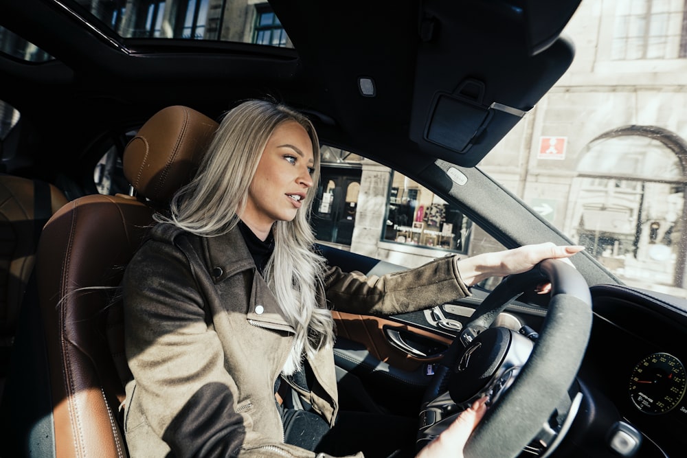 woman in gray coat driving car