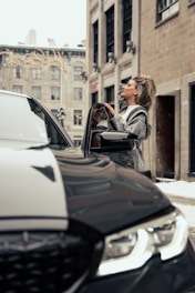 A professional inspecting a car exterior in an urban setting.