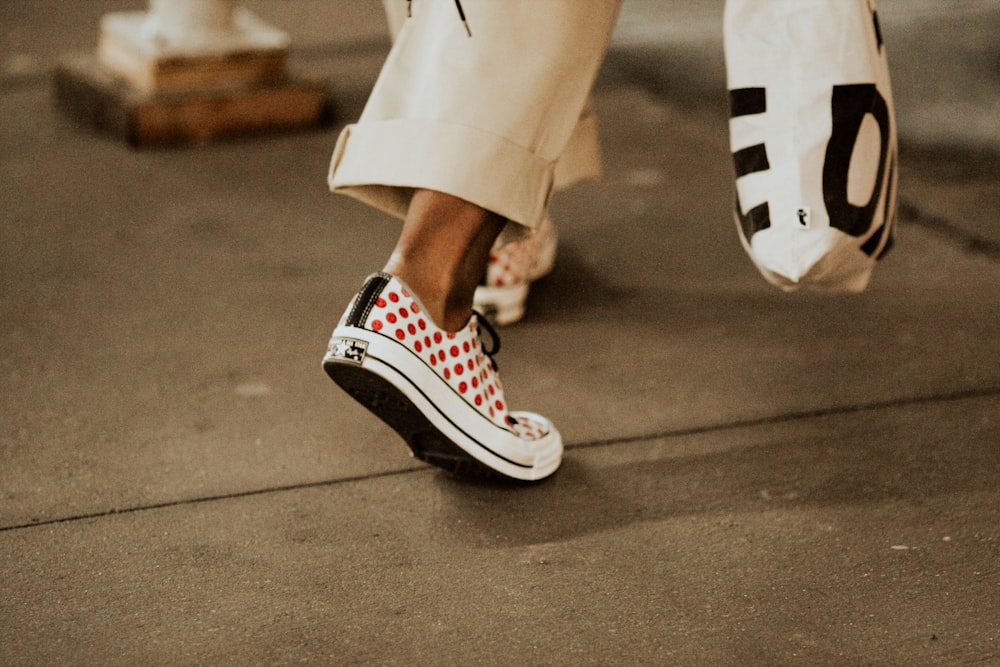 person in white pants and black and white sneakers