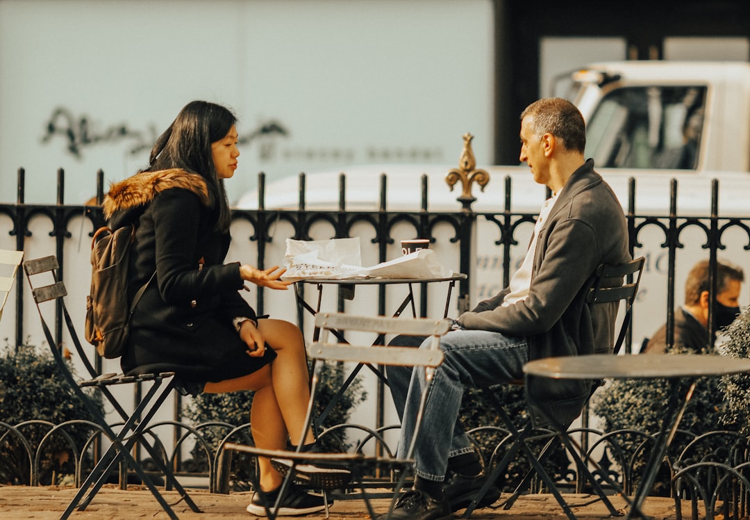 man and woman sitting on chair during daytime