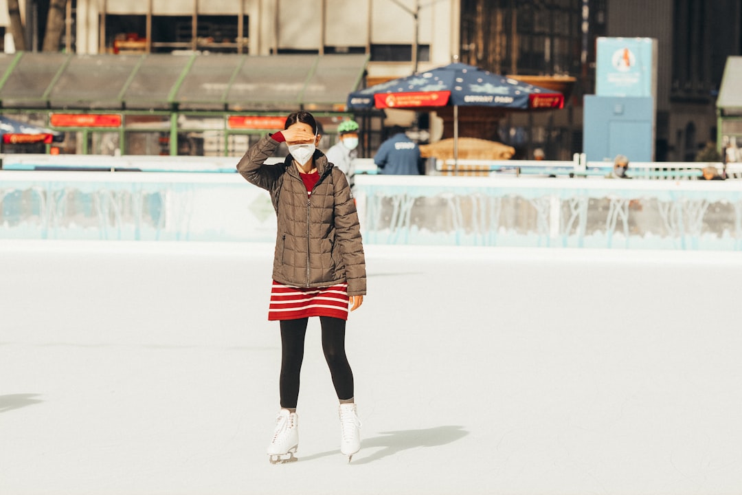 woman in red and black plaid coat and black pants standing on snow covered field during