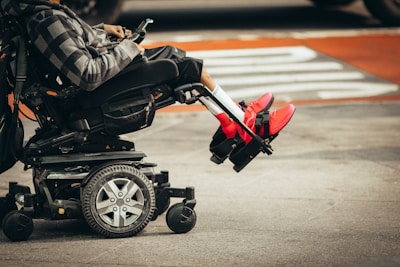 man in brown jacket and black pants in an electric wheelchair